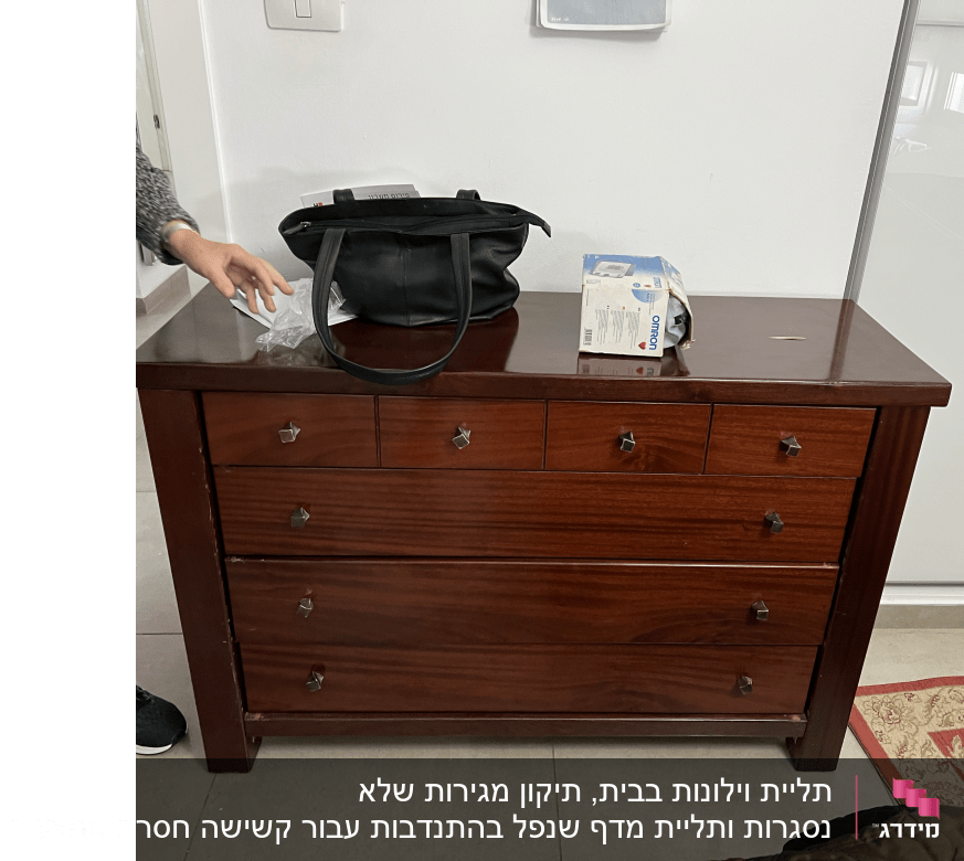 יד מושטת ליד שידה עם קופסת כלים